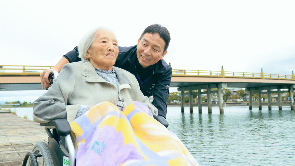 車椅子の女性に話しかける代表