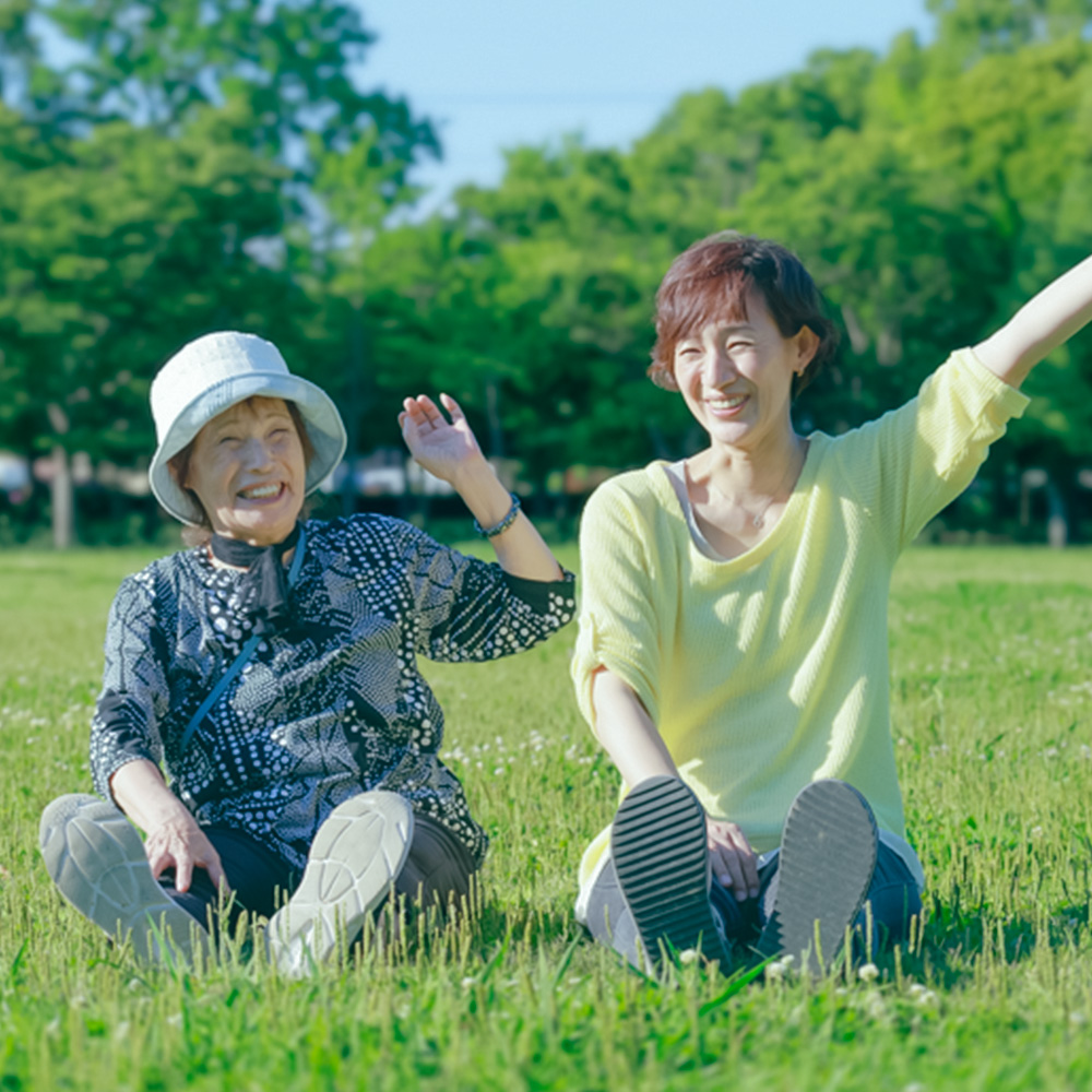 芝生の上に座る二人の女性