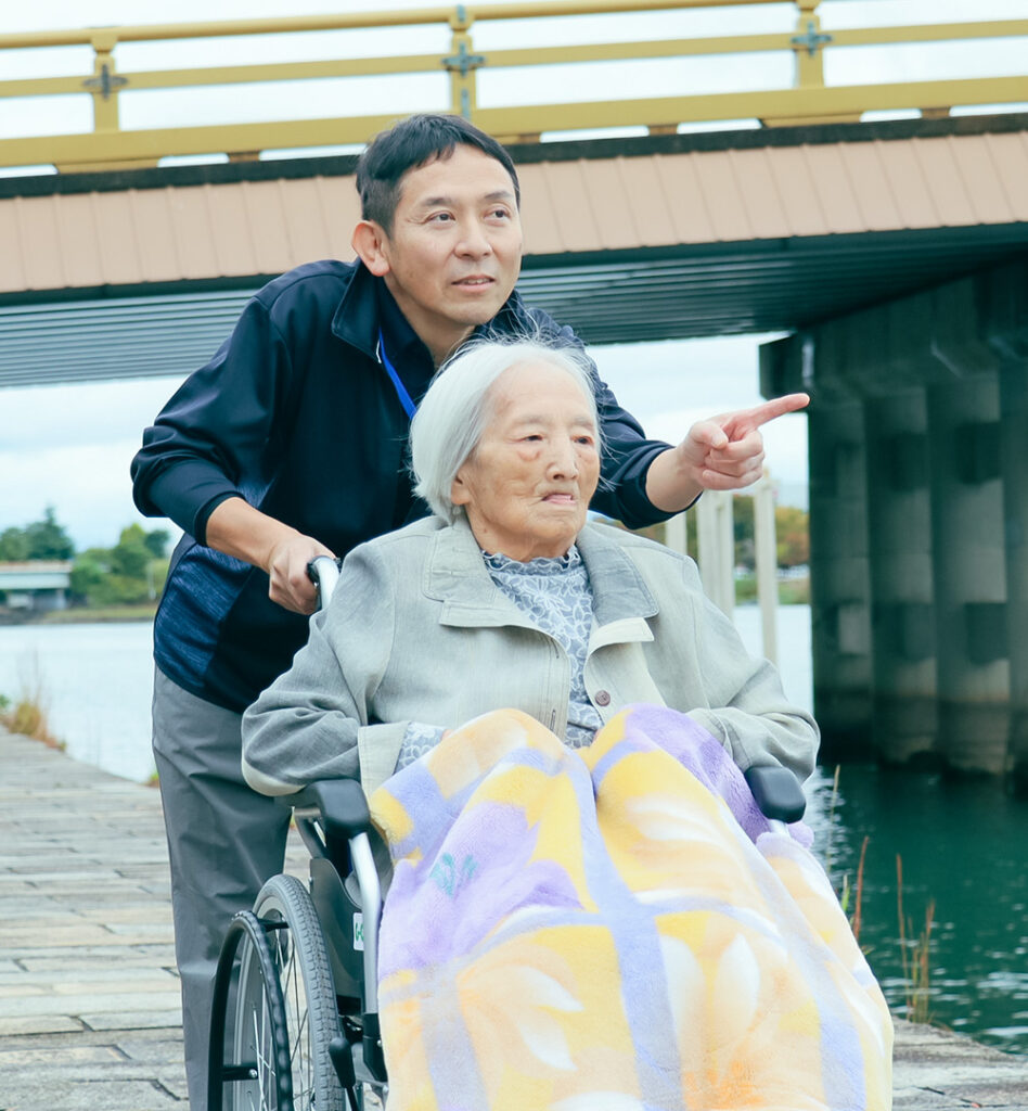 車椅子の女性に話しかける代表